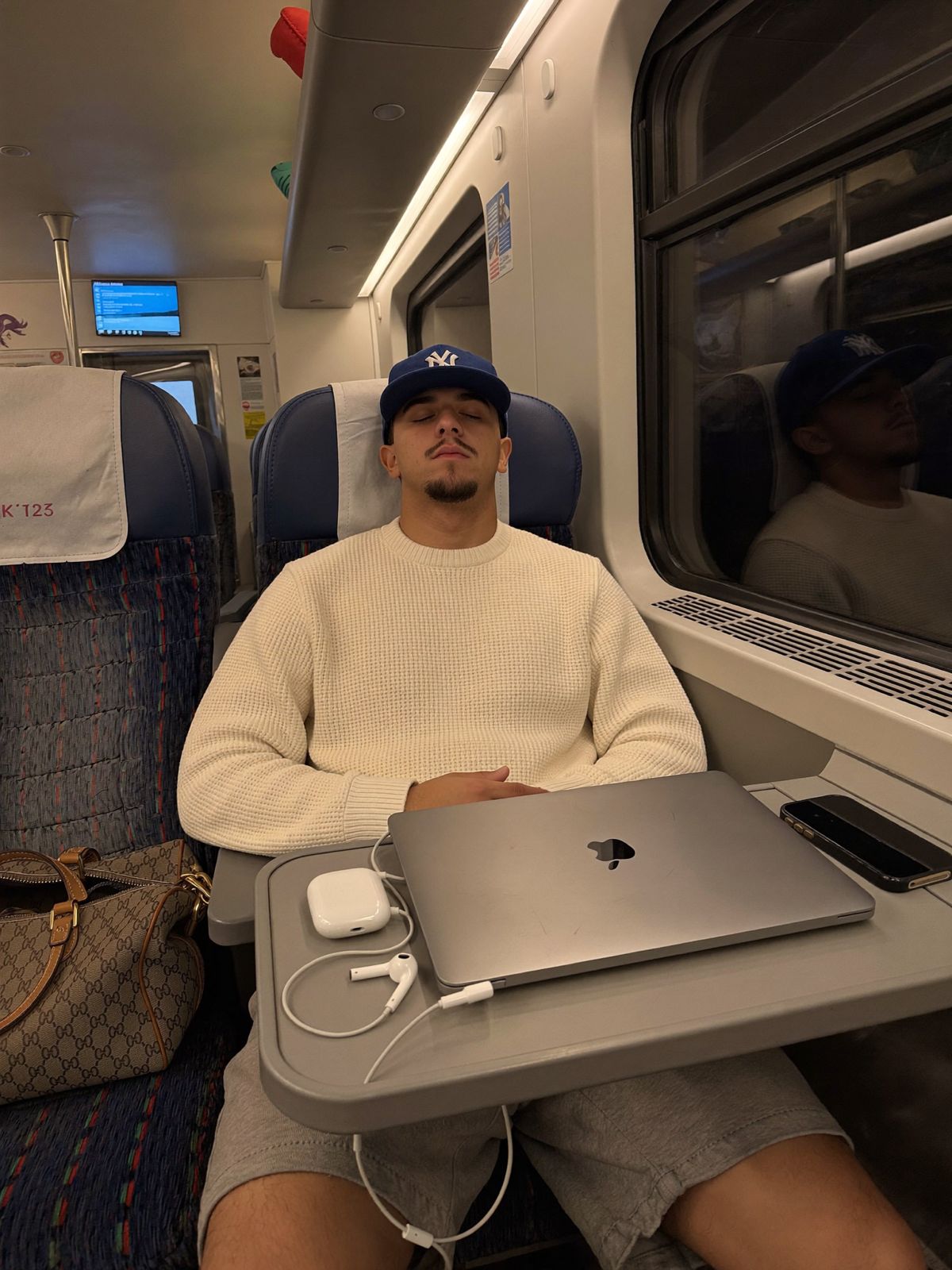 Diego riposa in treno accanto al laptop